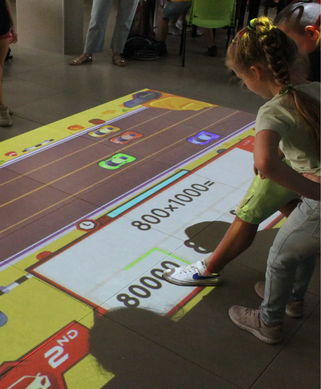 Students playing a math game on an interactive floor projection in a school