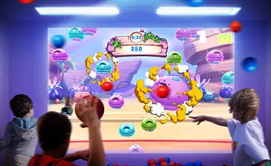 Children playing an interactive ball wall game
