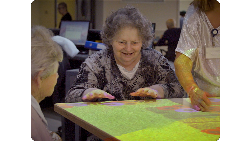 Senior resident using an EyeClick interactive projector