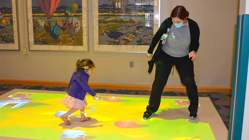 Young patient and nurse using an EyeClick interactive projector